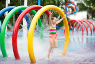Les enfants de cercle d'arc-en-ciel de parc de jet d'eau arrosent le parc coloré d'éclaboussure de l'eau de terrain de jeu